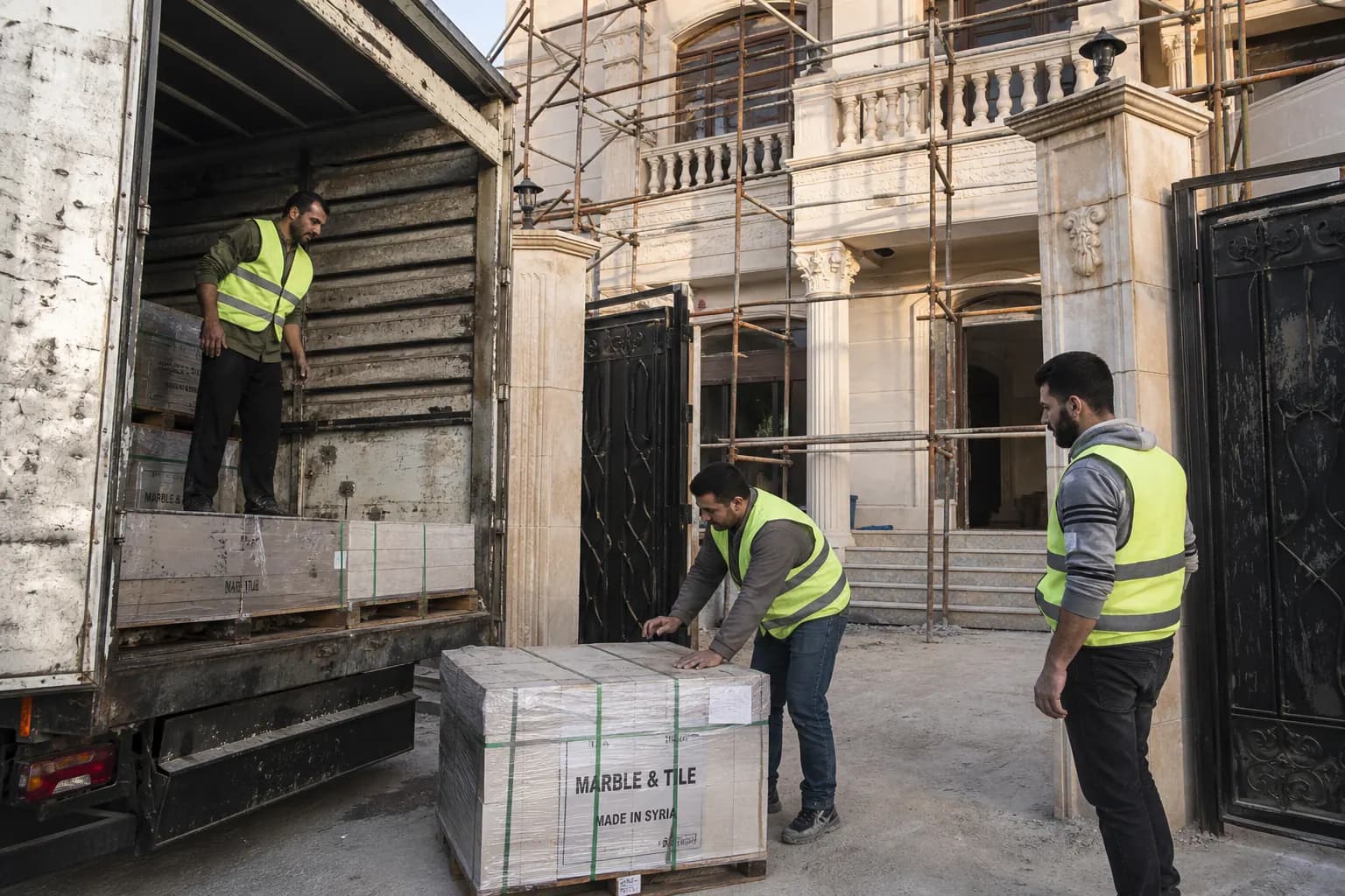 Damascus renovation site receiving labelled marble delivery during construction material procurement Syria